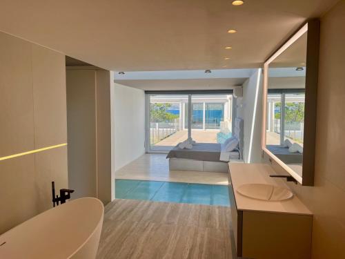 ein Bad mit einer Badewanne und einem Waschbecken in einem Zimmer in der Unterkunft Seafront Villa Sunset Alcudia in Alcúdia