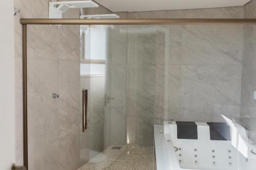 ein Bad mit einer Dusche und einer Glastür in der Unterkunft ALDRAVA POUSADA BOUTIQUE in Tiradentes