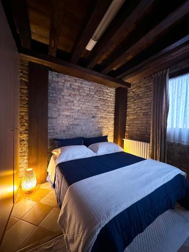 - une chambre avec un grand lit et un mur en briques dans l'établissement Ca Giobbe, à Venise