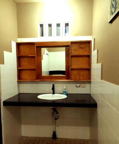 a bathroom with a sink and a mirror at Green Haven Homestay in Tetebatu