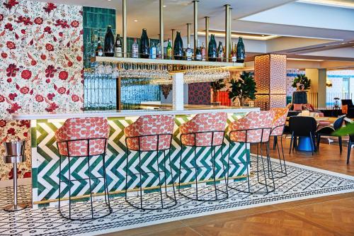 a bar with colorful bar stools in a restaurant at Hesperia Sevilla in Seville