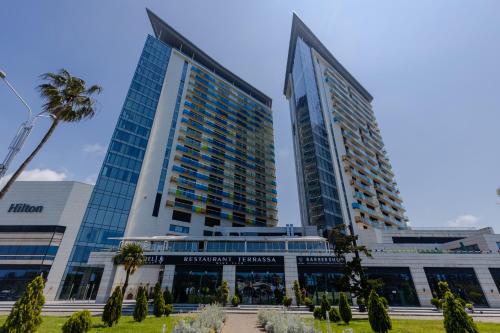 dos edificios altos con palmeras delante de ellos en Bellevue Residence Suites en Batumi
