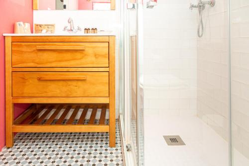 a bathroom with a wooden dresser and a shower at Casa rural "Cuenta la Leyenda..." in Bulbuente