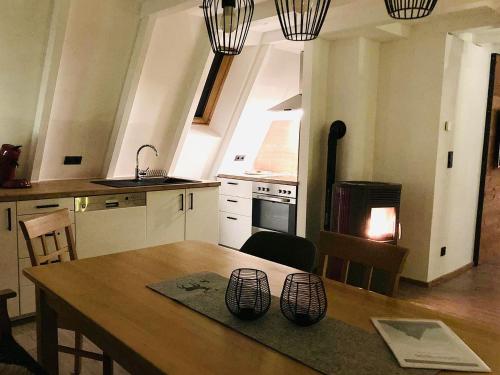 uma cozinha com uma mesa de madeira e uma cozinha com um fogão em Nurdachhaus Sauerland em Kirchhundem
