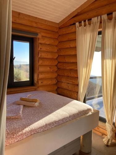 a bedroom with a bed in a log cabin at Mountain Log Cabin O Garrano in Cabeceiras de Basto