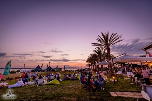 a crowd of people sitting in chairs on the beach at sunset at Resort Santa Maria Hotel in Birgi Vecchi