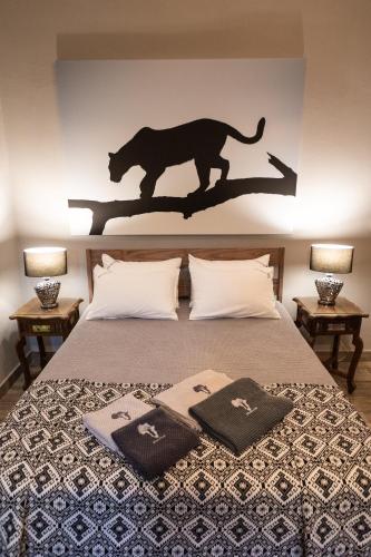 a bedroom with a tiger silhouette on the wall at Africa House in Hoedspruit