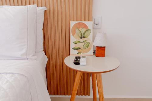a bedroom with a bed and a table with a lamp at ALDRAVA POUSADA BOUTIQUE in Tiradentes