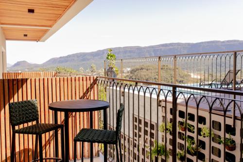 a balcony with two chairs and a table on a balcony at ALDRAVA POUSADA BOUTIQUE in Tiradentes