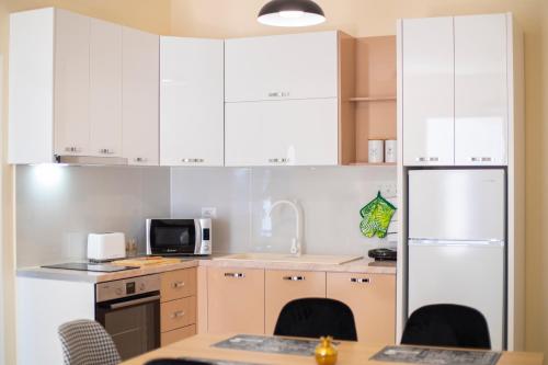 a kitchen with white cabinets and a white refrigerator at CAPTAIN'S RESIDENCE in Ksamil