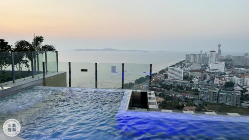 een zwembad bovenop een gebouw met uitzicht op de stad bij Copacabana Beach Jomtien 科帕卡巴纳海乔木提安海滩毗邻乔木提安夜市 in Jomtien Beach