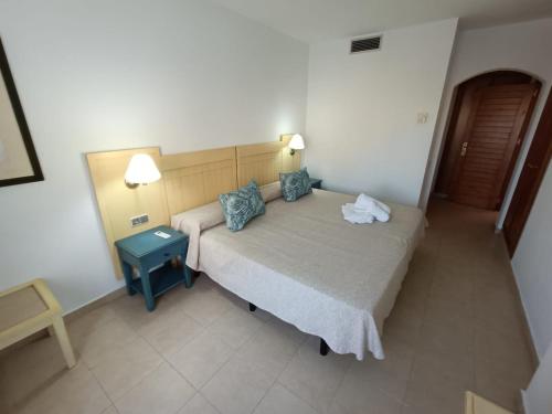 een kleine slaapkamer met een bed en een tafel bij APARTAMENTO EN SEGUNDA PLANTA EN URB. JARDINES DE ISLA CANELA in Ayamonte