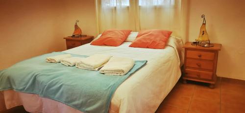 1 dormitorio con 1 cama con toallas en Balcón de la Alhambra y Sierra Nevada en Huétor Vega