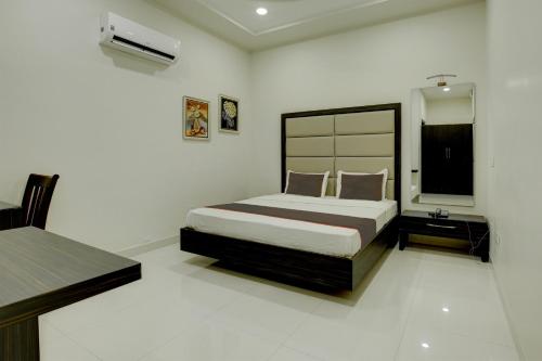 1 dormitorio con 1 cama y TV en Ovel Hotel Grand en Jalandhar