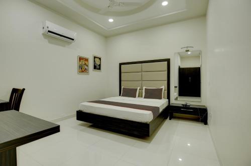 1 dormitorio con 1 cama y TV en Ovel Hotel Grand, en Ābādpura