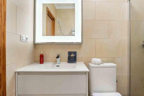 uma casa de banho com um lavatório, um espelho e um WC. em Charming House with private pool in urb saint Louis em Torrevieja