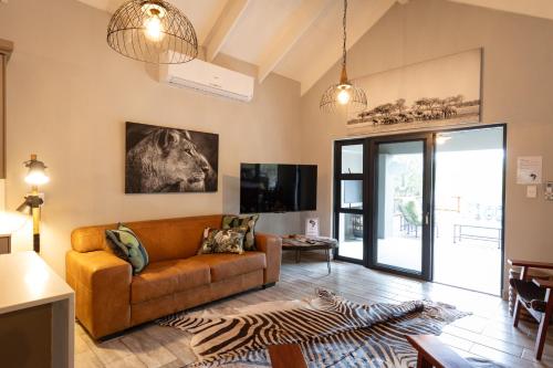 a living room with a couch and a tv at Africa House in Hoedspruit