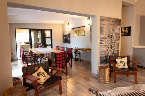 a living room with a dining room table and chairs at Africa House in Hoedspruit