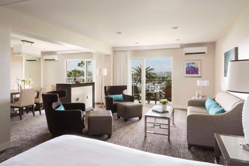 a hotel room with a bed and a living room at Hyatt Regency Newport Beach in Newport Beach