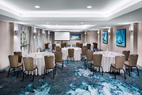 a conference room with tables and chairs and a screen at Hyatt Regency Newport Beach in Newport Beach