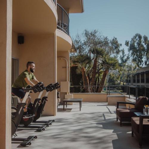 a man riding on an exercise bike outside of a building at Hyatt Regency Newport Beach in Newport Beach