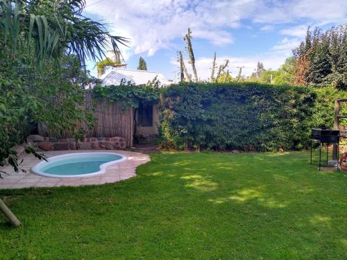 a backyard with a swimming pool in the grass at Casitas del Cerro in Chacras de Coria