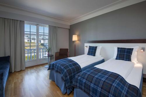 a hotel room with two beds and a balcony at Havna Tjøme Hotel in Tjøme