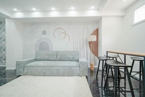 ein Wohnzimmer mit einem Sofa und einer Bar mit Hockern in der Unterkunft Appartement Mairie des Lilas - III in Les Lilas