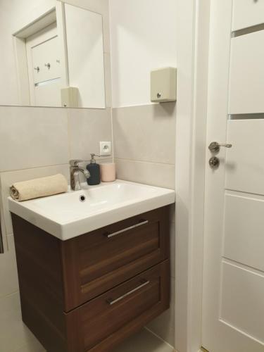 a bathroom with a sink and a mirror at Apartamenty pod Wilczakiem in Złotoryja