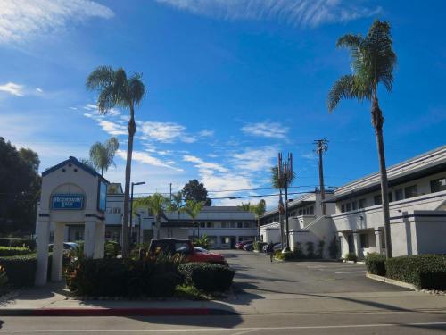ein Parkplatz vor einem Hotel mit Palmen in der Unterkunft Rodeway Inn Encinitas North in Encinitas