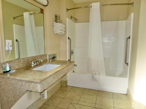 a bathroom with a sink and a shower and a tub at Rodeway Inn Encinitas North in Encinitas