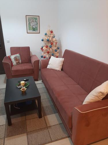 a living room with a couch and a christmas tree at Apricot garden in Kynopiástai