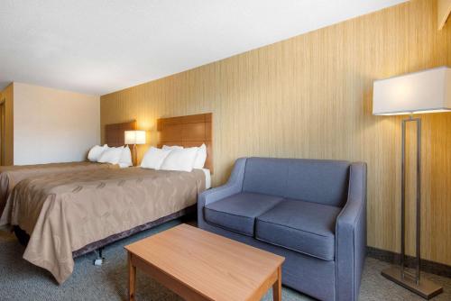 a hotel room with a bed and a chair at Quality Inn & Conference Centre Downtown Sudbury in Sudbury