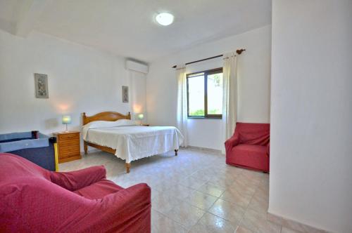 a bedroom with a bed and a red couch at Close to amenities, free air conditioning and wi-fi in Quarteira