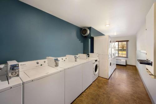 lavadero con electrodomésticos blancos y pared azul en WoodSpring Suites Columbus Southeast, en Groveport