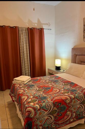 a bedroom with a bed with a colorful blanket at Hostal Rio Piedra in Estelí