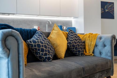 un divano con molti cuscini sopra di Modern Stylish 2 bedroom apartment in the heart of Potters Bar a Potters Bar