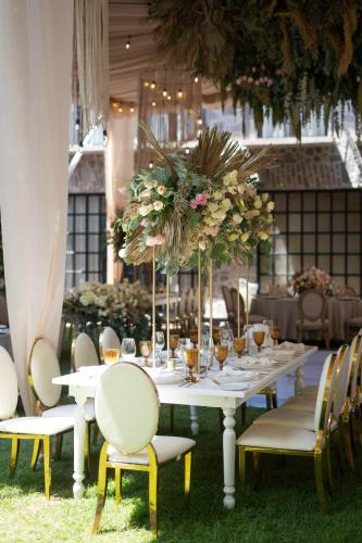 a white table with chairs and flowers on it at Banyan Tree Puebla in Puebla