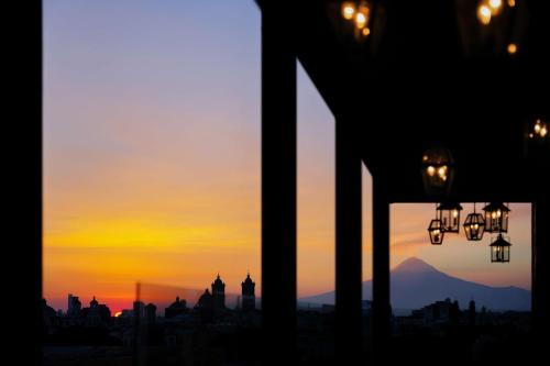 a view of the sunset from a building with a window at Banyan Tree Puebla in Puebla