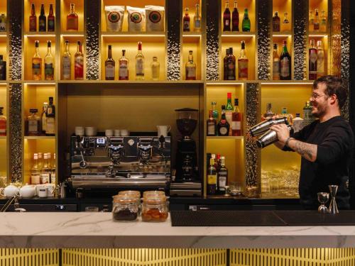a man standing at a bar preparing a drink at TRIBE Lyon Croix Rousse in Lyon