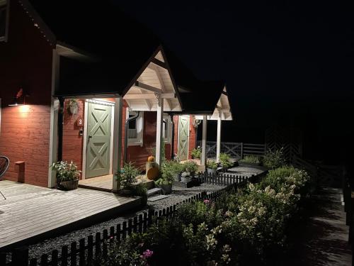 a house with a porch with potted plants on it at Wioska w Sowich Sokolec in Sokolec