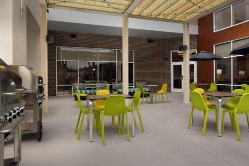 a cafeteria with tables and yellow chairs and tables at Hampton Inn & Suites Durham University Medical Center in Durham