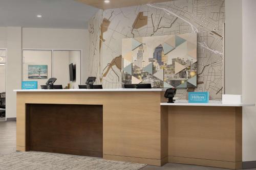 a lobby with a reception desk with a large painting at Hampton Inn & Suites Durham University Medical Center in Durham