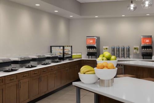 a kitchen with bowls of fruit on a counter at Hampton Inn & Suites Durham University Medical Center in Durham