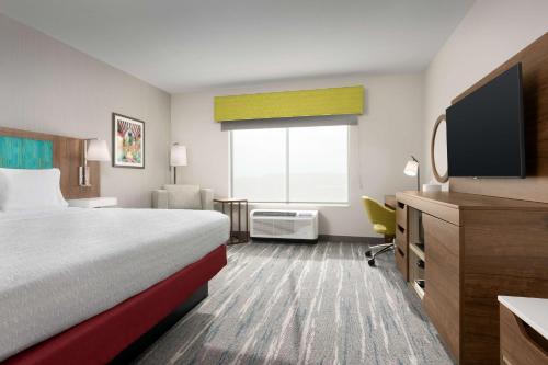 a hotel room with a bed and a flat screen tv at Hampton Inn & Suites Durham University Medical Center in Durham