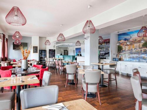 a restaurant with tables and chairs and a bar at HOTEL Lyon Nord Massieux Genay in Massieux