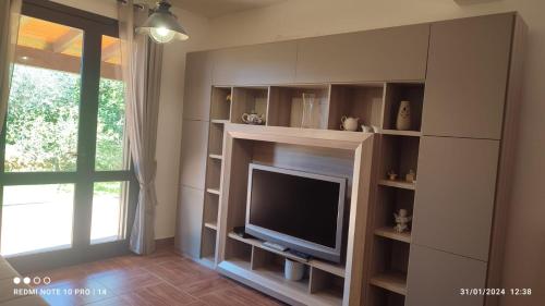 sala de estar con TV de pantalla plana en la pared en ViViHolidays, en Castellammare del Golfo