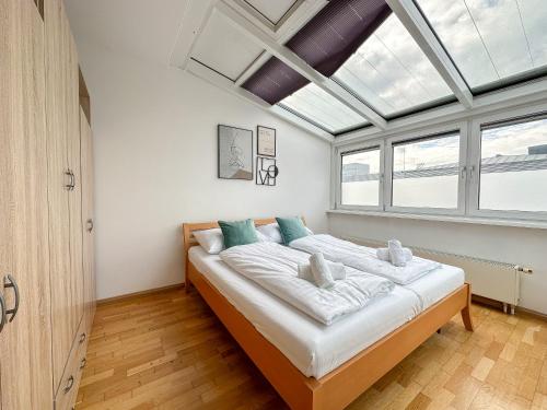 een slaapkamer met een groot bed en een dakraam bij FeelHome-Prater-Ausblick-Terrasse-6 Gäste-WiFi-Smart TV in Wenen