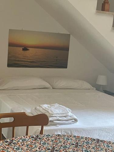 um quarto com uma cama com uma fotografia na parede em Gallipoli Il mare in una stanza em Lido Conchiglia