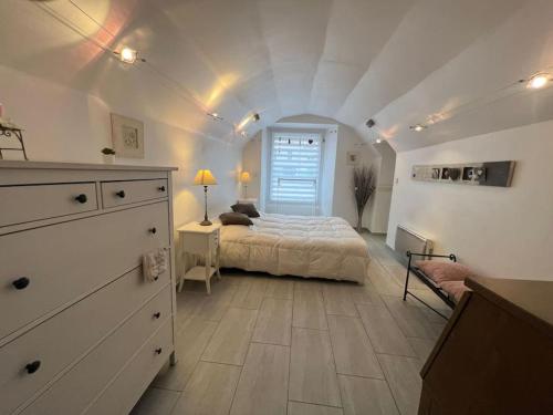 sypialnia z łóżkiem i komodą w pokoju w obiekcie Le Tonneliers - bel appartement au centre Mulhouse w Miluzie